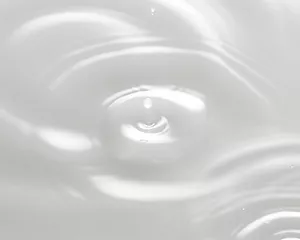 Lotion is dripping, creating ripples on the surface.