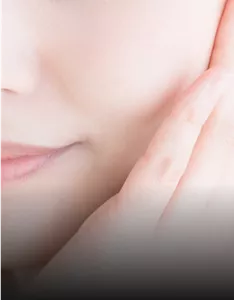 Close-up of a woman's lower face with hand touching cheek